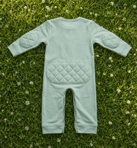Green Tea padded onesie back view showing knee padding on cream linen backdrop