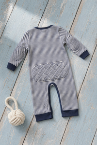 Navy Stripe padded onesie back view on grass with daisies
