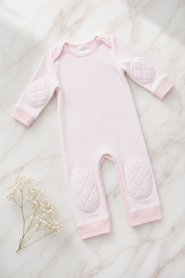 Pink Stripe padded onesie on white marble with baby's breath - front view of narrow pink and cream stripes